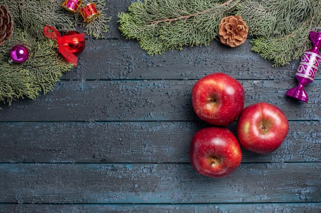 Vista superior de manzanas rojas frescas frutas maduras suaves en una planta de escritorio azul oscuro muchas frutas color rojo vitamina fresca