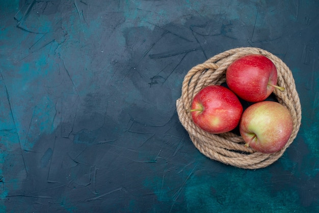 Vista superior de manzanas rojas frescas jugosas y suaves sobre el fondo azul oscuro fruta madura vitamina suave fresca