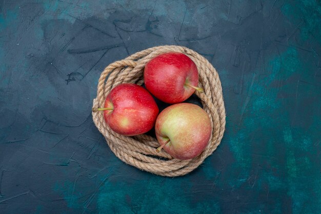 Vista superior de manzanas rojas frescas jugosas y suaves en la superficie azul oscuro fruta madura fresca suave