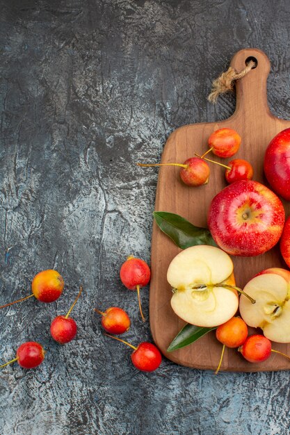 Vista superior manzanas la tabla de cortar con cerezas manzanas