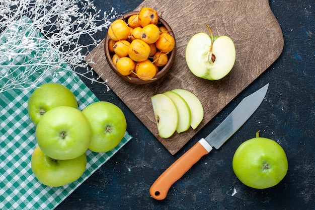 Vista superior de manzanas verdes frescas con cerezas dulces suaves en el escritorio oscuro, fruta fresca suave