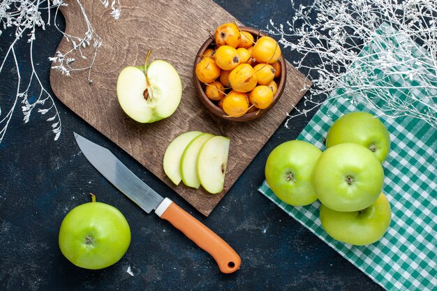 Vista superior de manzanas verdes frescas con cerezas dulces suaves en piso oscuro fruta fresca suave