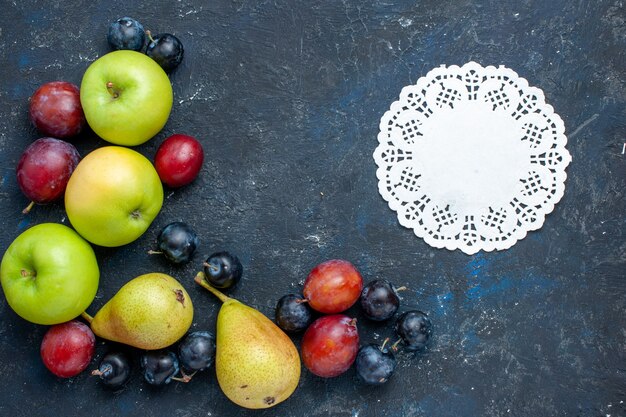 Vista superior de manzanas verdes frescas con peras endrinos y ciruelas en el escritorio azul oscuro, comida suave fresca de bayas de frutas