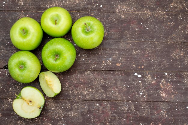 Vista superior manzanas verdes frescas en rodajas y enteras en la oscuridad