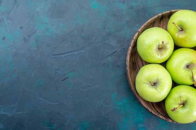 Vista superior manzanas verdes frescas suaves en el escritorio azul oscuro