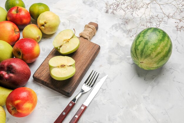 Vista superior de manzanas verdes con otras frutas sobre fondo blanco claro