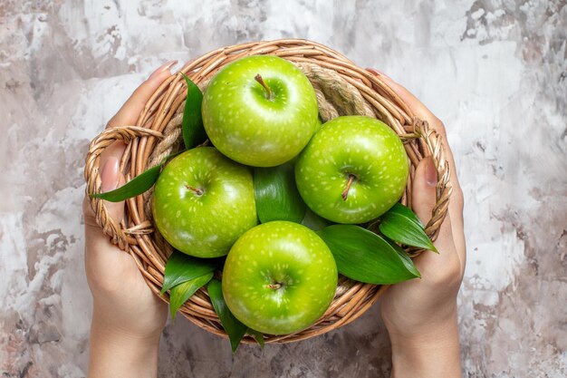 Vista superior de manzanas verdes en rodajas dentro de la cesta sobre fondo claro