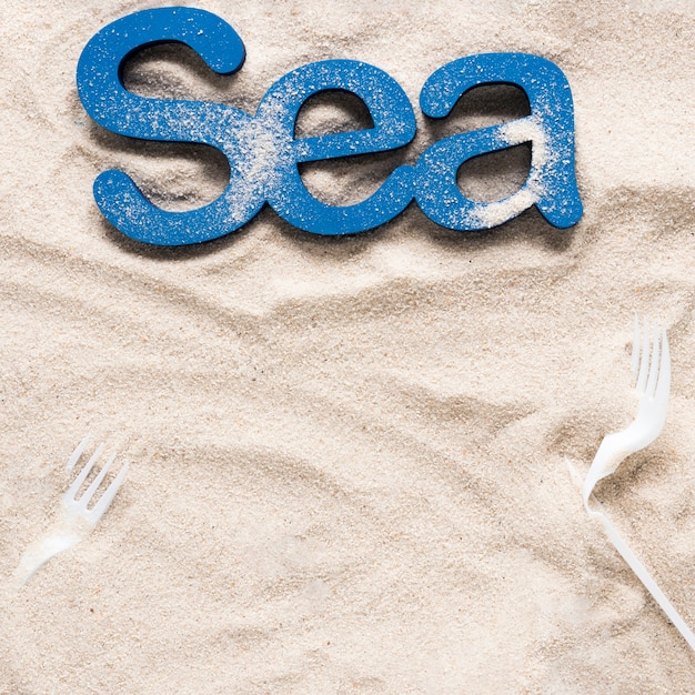 Vista superior del mar en las arenas de la playa con tenedores de plástico