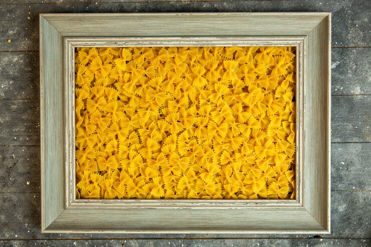 Foto gratuito vista superior de un marco de madera relleno de pasta cruda farfalle