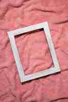 Foto gratuita vista superior marco de madera sobre manta rosa