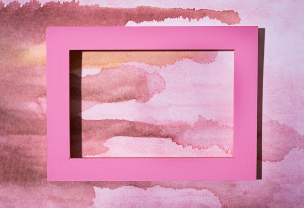 Vista superior marco rosa sobre fondo pintado a mano