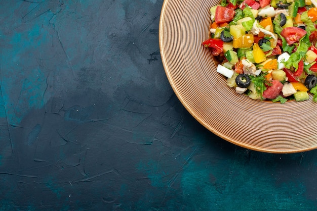 Foto gratuita vista superior más cercana ensalada de verduras en rodajas salpicado dentro de la placa en el escritorio azul oscuro ensalada comida vegetal comida snack almuerzo