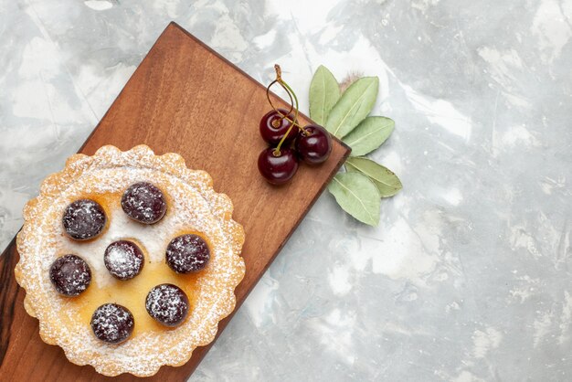 Vista superior más cercana del pastelito con frutas de azúcar en polvo en la luz