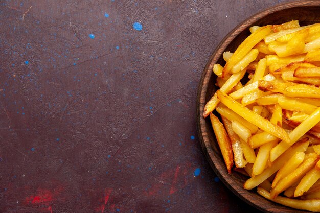 Vista superior más cercana patatas fritas sabrosas patatas fritas dentro de la placa en la superficie oscura comida comida cena plato ingredientes producto patata