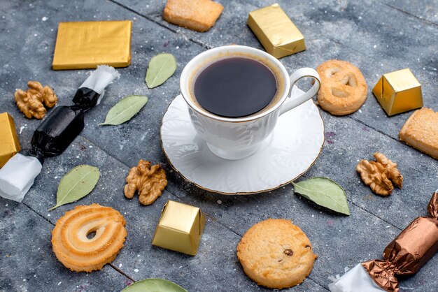 Vista superior más cercana de la taza de café con galletas nueces en gris