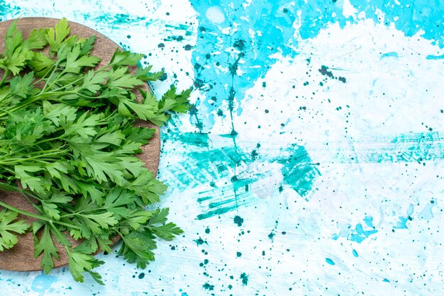 Vista superior más cercana de verduras frescas aisladas sobre un escritorio de madera marrón y azul brillante