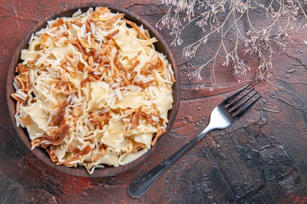 Vista superior de masa cocida en rodajas con arroz en la masa de plato de pasta de comida de superficie oscura