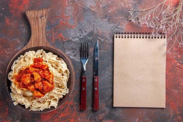 Vista superior de la masa cocida con salsa de carne en un plato oscuro de masa de pasta de superficie oscura