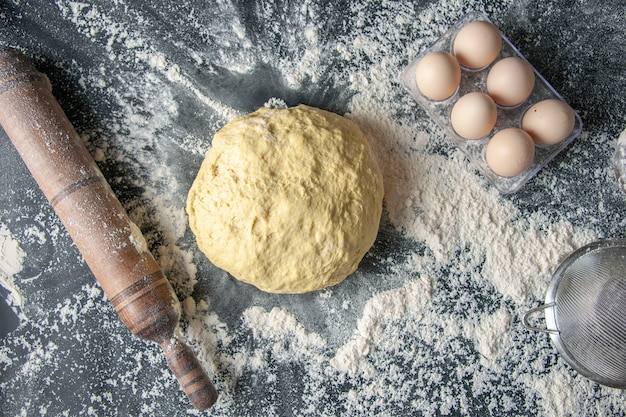 Vista superior de masa cruda con huevos y harina blanca sobre fondo oscuro masa huevo panadería hotcake pastelería cocina cocina