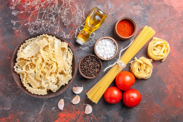 Vista superior de masa cruda en rodajas con condimentos en pasta de superficie oscura alimentos pasta oscura