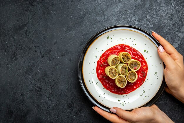 Vista superior de la masa con rodajas de carne en rodajas con salsa de tomate en el espacio gris