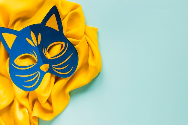 Vista superior de la máscara felina de carnaval en textil con espacio de copia