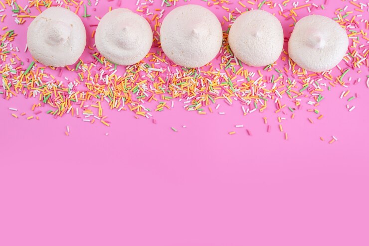 Foto gratuito una vista superior de merengues dulces con caramelos de colores en el escritorio rosa, bizcocho de azúcar dulce