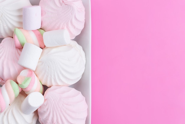Una vista superior de merengues y malvaviscos dulces y deliciosos en rosa, galleta dulce azúcar dulce