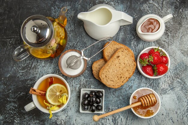 Vista superior mesa de desayuno pan miel y té en la superficie oscura té comida mañana