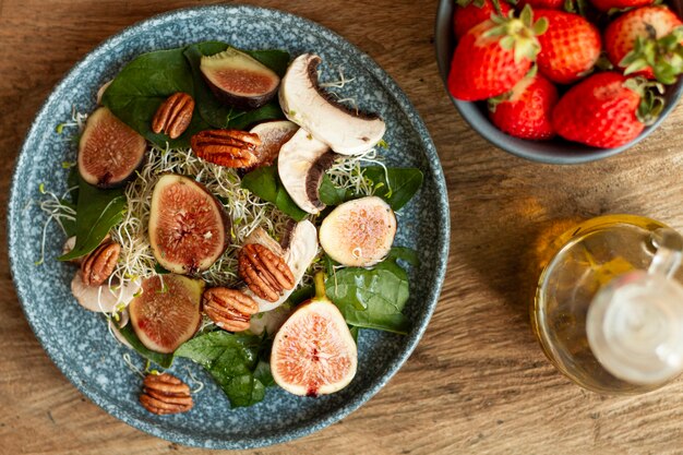 Vista superior mezcla de nueces e higos en un plato con fresas