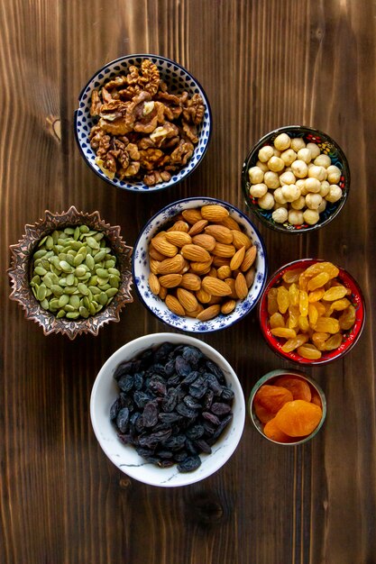 Vista superior mezcla de nueces y frutas secas almendras pasas semillas de calabaza con albaricoques secos sobre una mesa