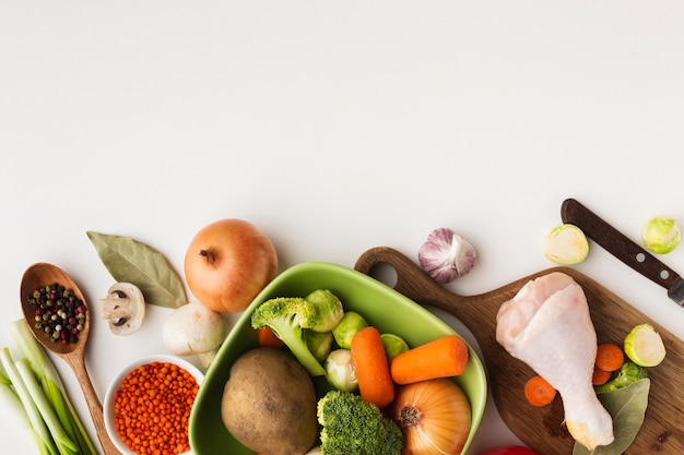 Vista superior mezcla de verduras en la tabla de cortar y en un recipiente con espacio de copia