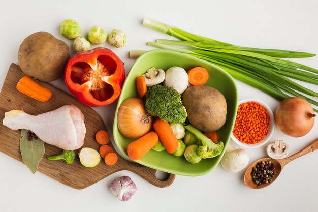 Vista superior mezcla de verduras en la tabla de cortar y en un tazón