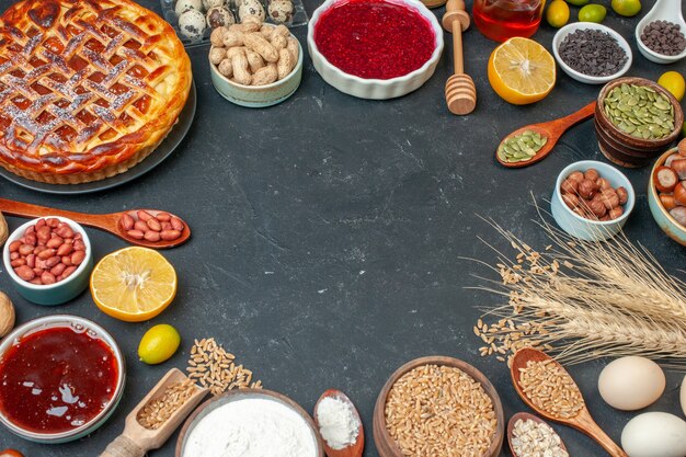 Vista superior de la mitad del delicioso pastel de frutas con huevos y nueces en la mesa oscura