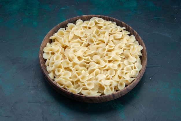 Vista superior de la mitad de la pasta italiana dentro de la placa en azul oscuro