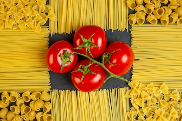 Vista superior montón de tomates con pasta y espagueti en forma de decoración