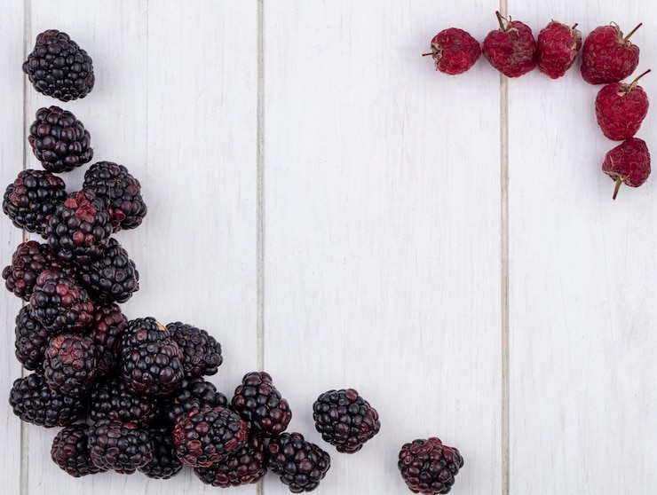 Foto gratuito vista superior de moras con frambuesas sobre una superficie blanca