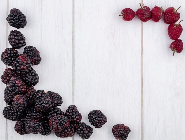 Foto gratuito vista superior de moras con frambuesas en una superficie blanca