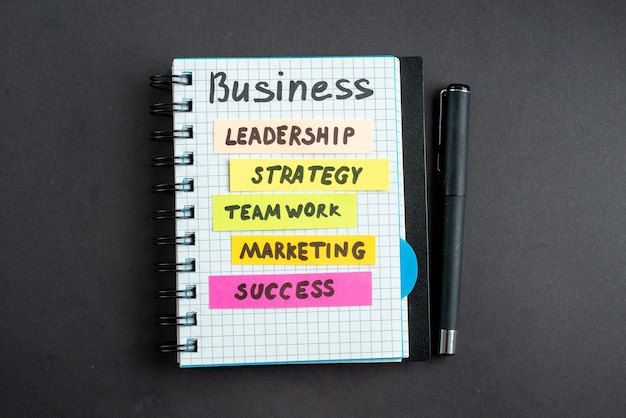 vista superior motivación notas comerciales con bolígrafo sobre fondo oscuro marketing empresarial trabajo éxito estrategia laboral trabajo en equipo liderazgo de la oficina