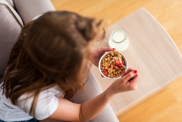 Vista superior mujer comiendo cereales