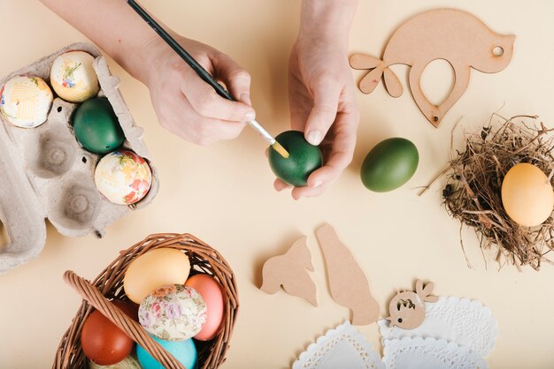 Vista superior de mujer decorando huevos de pascua