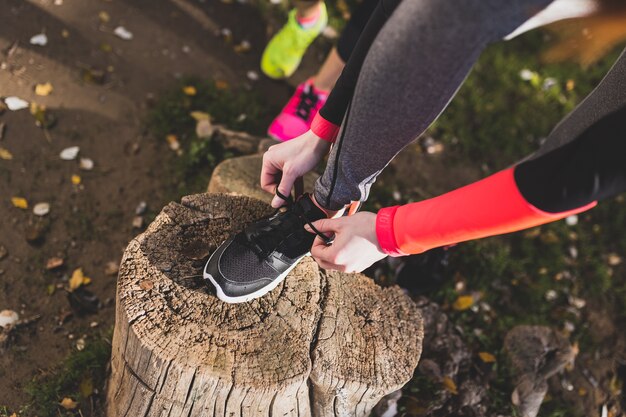 Vista superior de mujer deportista atándose los cordones