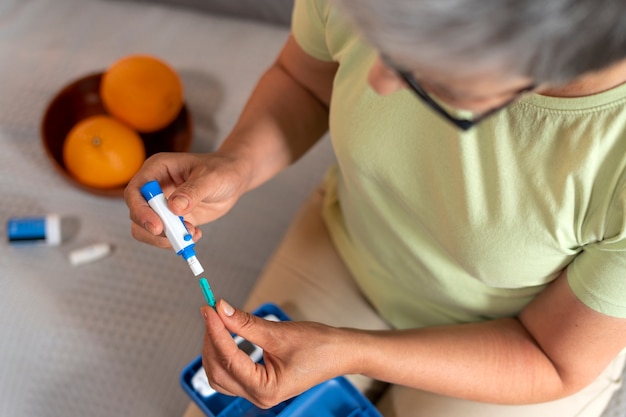 Foto gratuita vista superior mujer diabética comprobando su nivel de glucosa