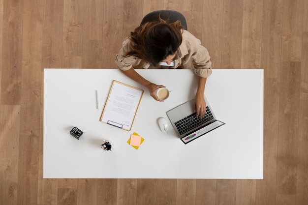 Vista superior de la mujer que trabaja en el escritorio