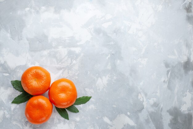 Vista superior naranja mandarinas cítricos enteros en el escritorio blanco jugo de frutas exóticas cítricos