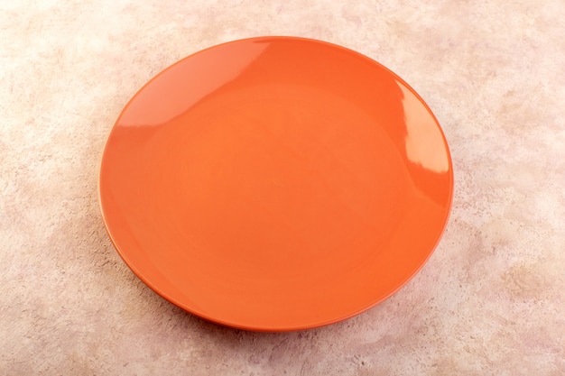 Una vista superior naranja plato redondo vidrio vacío hecho aislado color de la tabla de comida