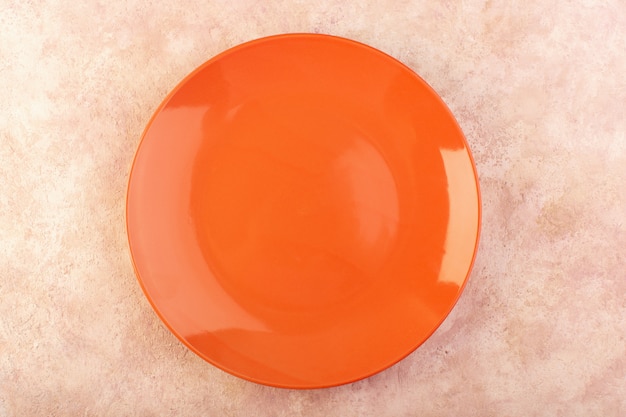 Una vista superior naranja plato redondo vidrio vacío hecho mesa de comida aislada