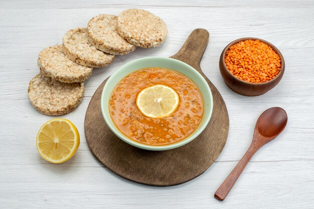 Vista superior naranja sabrosa sopa con galletas de rodaja de limón en blanco, comida comida cena sopa