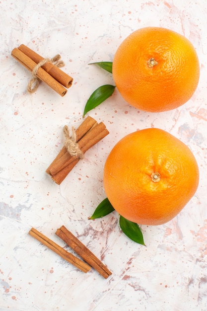 Foto gratuita vista superior naranjas frescas palitos de canela en superficie brillante