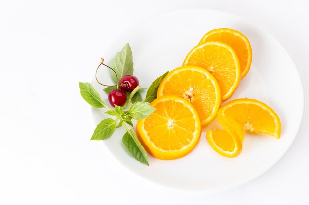 Vista superior de naranjas frescas en rodajas dentro de la placa blanca en el escritorio blanco jugo de color de frutas exóticas